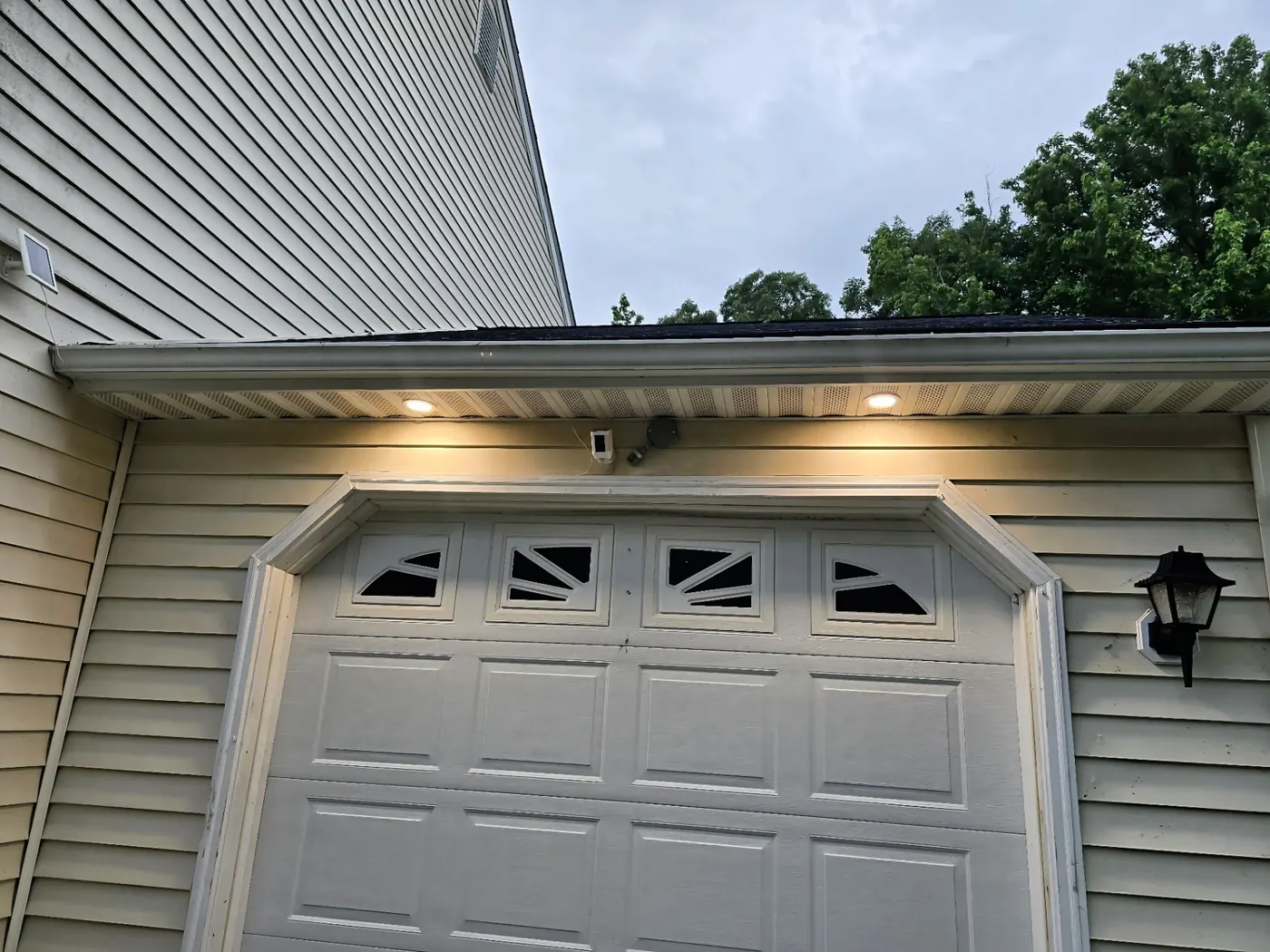 Garage Soffit Recessed Lighting — Evenly spaced soffit recessed cans light a residential garage exterior.